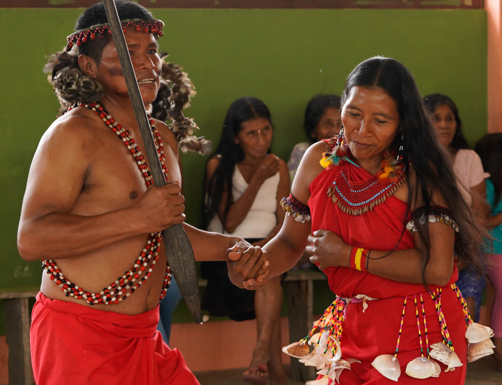 An Awajún man and woman dancing together in traditional dress